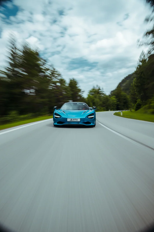 Blauer McLaren auf einer Bergstraße im Hochformat