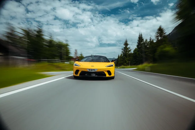 Gelber McLaren in Fahrt auf einer Alpenstraße