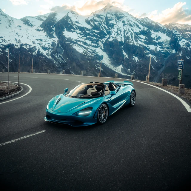 Türkisfarbener McLaren 720S Spider auf einer Alpenpassstraße