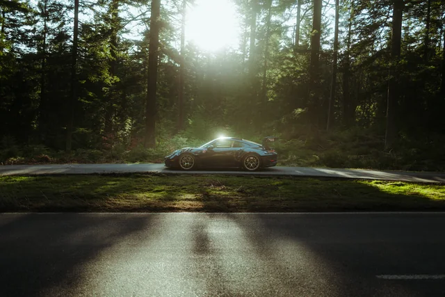 Porsche 911 GT3 RS im Gegenlicht auf einer Waldstraße